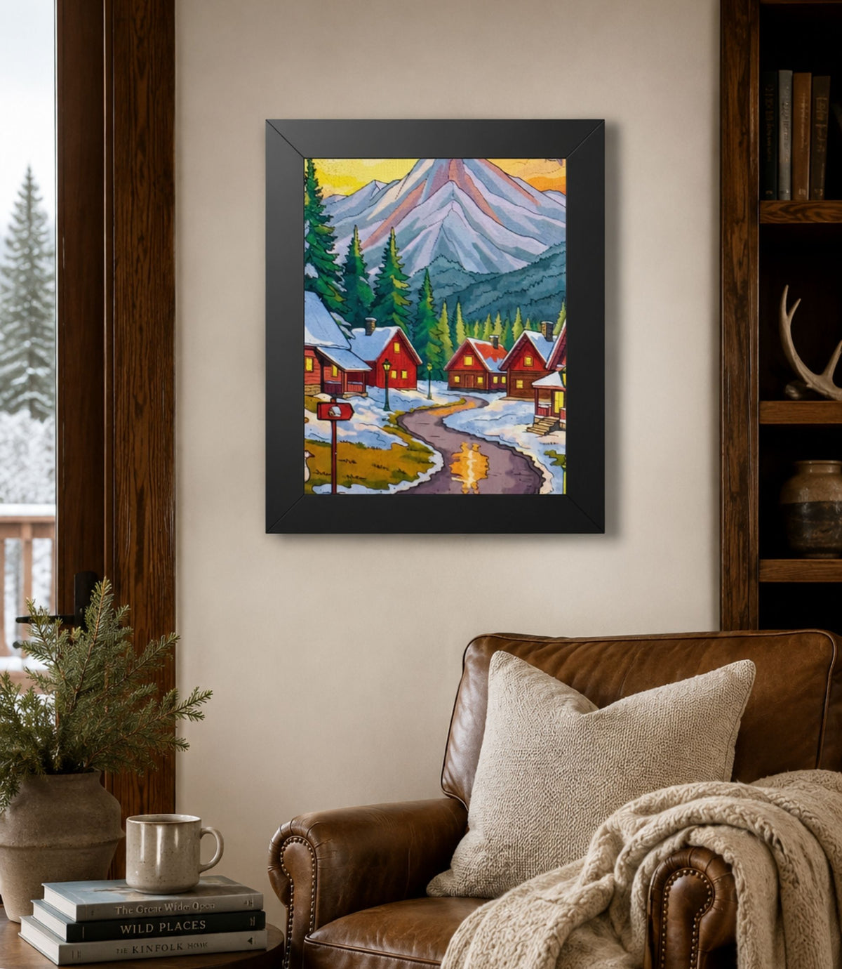 Black-framed winter mountain village poster displayed in a modern interior