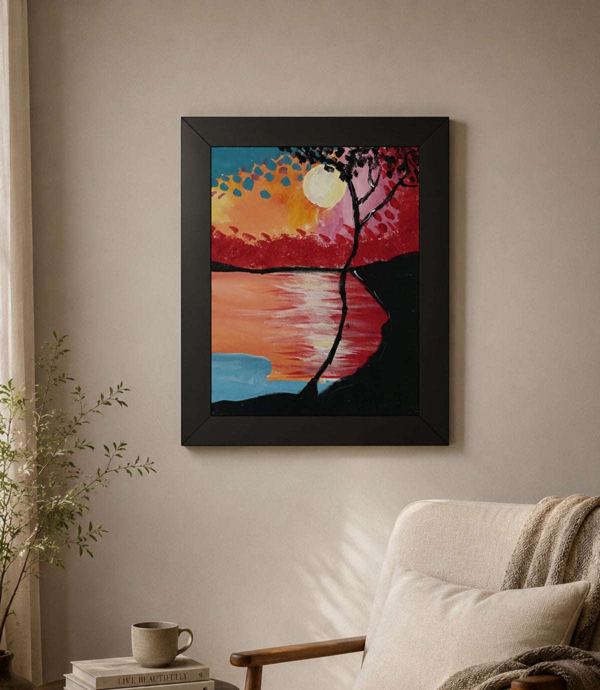 Black-framed sunset lake and silhouetted tree poster displayed in a modern interior