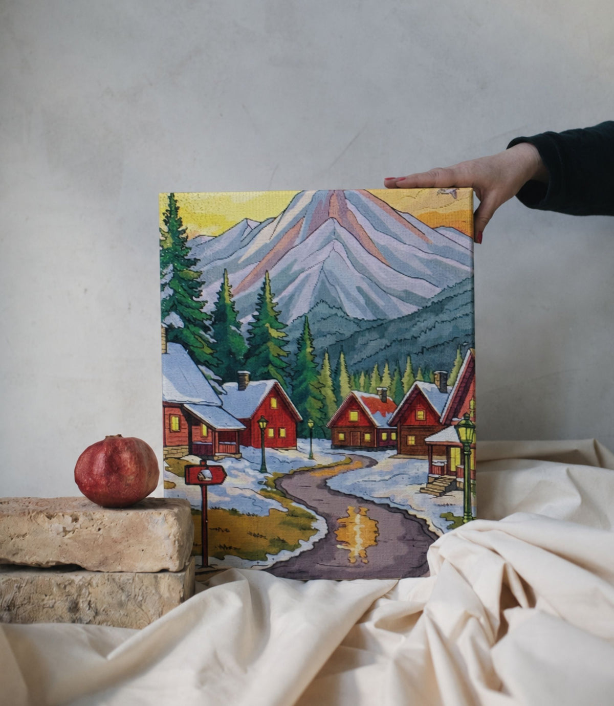 Person holding winter mountain village stretched canvas wall art